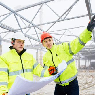 engineers construction foreman managers outdoors indoors at building site with blueprints